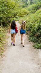 Two beautiful women hiking in nature  on a mountain road