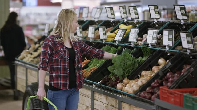  Young woman shopping for vegetables at the grocery store