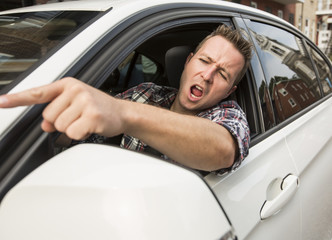 Irritated young man driving a car. Irritated driver