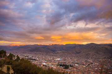 Panoramic view of Cusco town with glowing cloudscape and colorful sky at dusk. Cusco is among the most important travel destination in Peru and the entire South America.