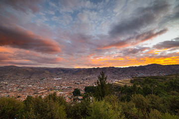 Panoramic view of Cusco town with glowing cloudscape and colorful sky at dusk. Cusco is among the most important travel destination in Peru and the entire South America.