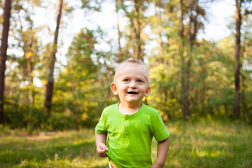 Cute little boy smiling in park, with copy space