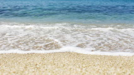 Fototapeta na wymiar Soft wave of blue ocean on sandy beach. Background