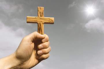 man holding wooden cross