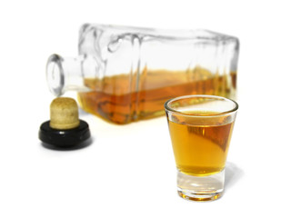 shot glass of delicious whiskey and open bottle