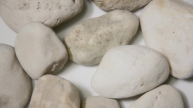 Rotating smooth stones from the sea bed. Close-up above shot.
