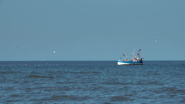 Fishing trawler boat in sea at the distance