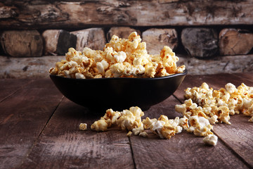 Salt popcorn or sweet popcorn in bowl on the wooden table