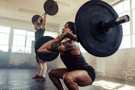 Woman doing front squats at gym