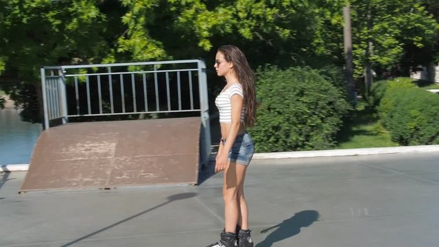 Beautiful teen girl roller-skating. A girl with a beautiful body on rollers.