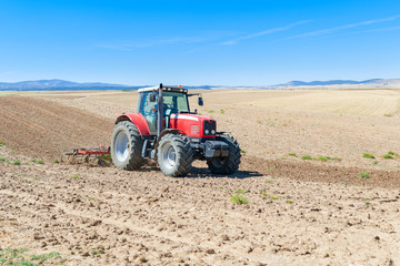 Obraz premium agricultural tractor in the foreground with blue sky background.