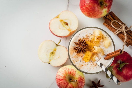 Healthy vegan food. Dietary breakfast or snack. Apple pie smoothies, with apples, yogurt, cinnamon, spices, walnuts. In a glass, on a white marble table. Copy space top view
