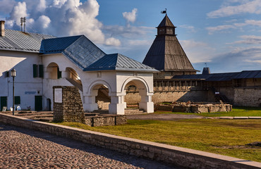 Buildings of the Pskov Kremlin/The summer day. Clouds in the sky. Area of the Pskov Kremlin buildings. In the background is a wooden watchtower.Russia, Pskov region, history