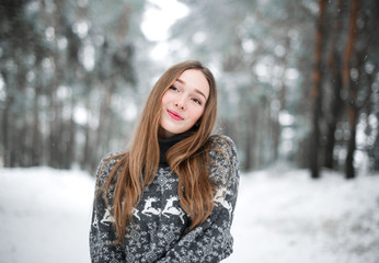 Winter portrait of young beautiful brunette woman wearing sweater. Snowing winter beauty fashion concept.