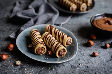 Photo sur Plexiglas Bonbons Biscuit tubes filled with hazelnut cream and chocolate topping