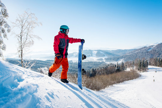 Professional snowboarder standing on top of a slope looking around enjoying the view on winter ski resort Bukovel in the sunny morning copyspace mountains landscape lifestyle concept