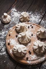 Pile of homemade raw khinkali dumplings close up on the wood rustic table.