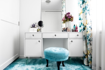 Modern white, feminine dressing room with minimalist vanity table and mirror