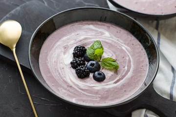 Berries smoothie in the black bowl. Healthy breakfast close up