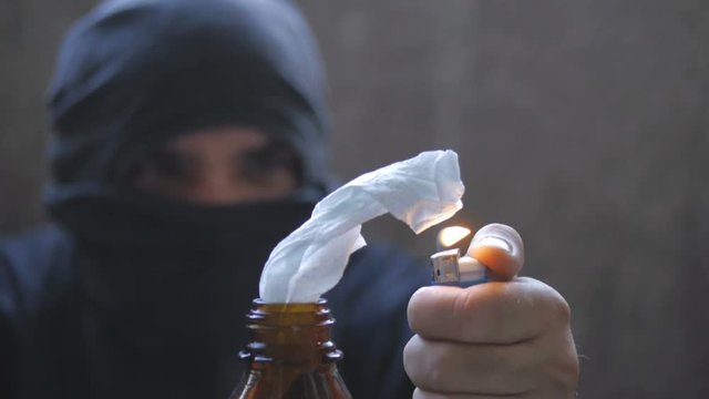Black bloc anarchist is lighting molotov cocktail