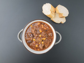 Chili con Carne mit drei Scheiben Brot im Topf aus der Vogelperspektive