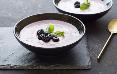 Berries smoothie in the black bowl. Healthy breakfast close up