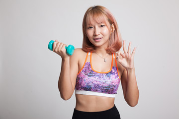 Beautiful Asian healthy girl show OK with dumbbell.