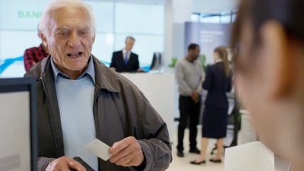  Worker at customer service desk assisting queue of customers in modern bank