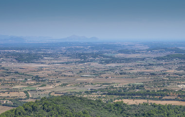 View from the mountain near the capital of the island Palma de Mallorca. Filds with mountains covered with haze