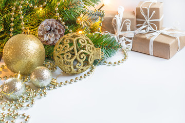 Christmas and New Year's background. A branch of a Christmas fir-tree with garlands, gifts, spheres, toys and decorating for a Christmas tree. A festive background with confetti of stars and bulbs.