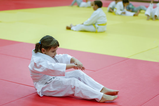 Little judo girl practising back fall