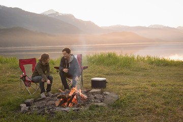 Couple enjoying time together near campfire at campsite