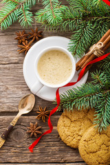 A cup of coffee with the branches of the Christmas tree on a wooden table
