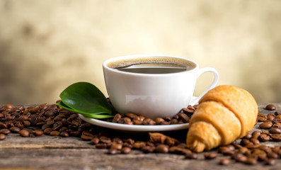 Coffee cup and saucer on a wooden table. Dark background