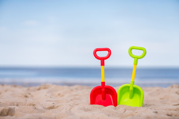 Plastic toy shovels on the beach