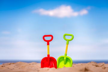 Plastic toy shovels on the beach