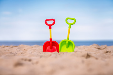 Fototapeta na wymiar Plastic toy shovels on the beach