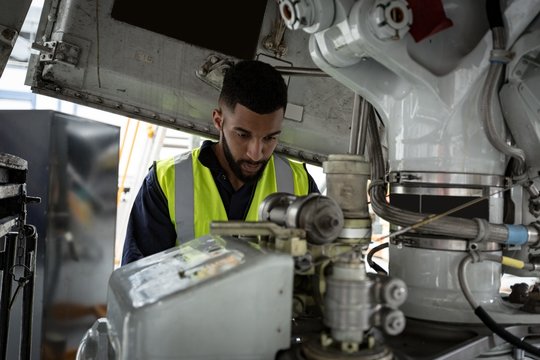Male aircraft maintenance engineer examining engine of an