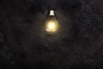 One Glowing light bulb in the middle of dark ..shimmering background. Creativity and new idea concept, copy space