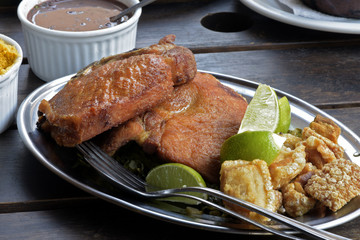 Fried pork steak and crackers, side dishes of feijoada
