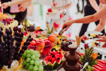 people group in the line catering buffet food indoor in luxury restaurant with colorful fruits and chocolate