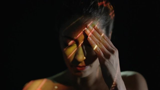 Light projected onto woman's face indicating brain activity or migraine