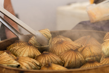 Sticky rice dumpling is being heated to prepare for sale to customers in the market