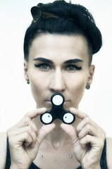 beauty portrait of young woman smiling with geometrical arrows eye make up carrying spinner in hand