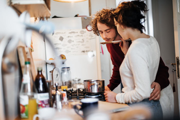 Young couple cooking together in a kitchen.