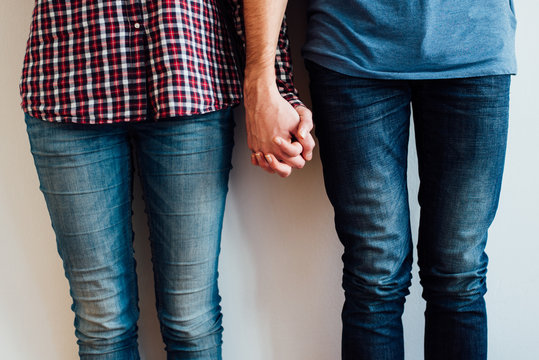 Couple in Denim Pants Holding Each Others Hands