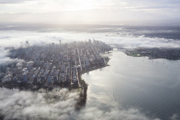 Aerial view of Downtown Vancouver, British Columbia, Canada, covered in clouds. Taken during a foggy winter sunrise.