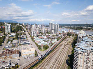 Fototapeta premium New Westminster, Greater Vancouver, BC, Canada - June 11, 2017 - Aerial view of the city, shopping mall and railroad tracks.