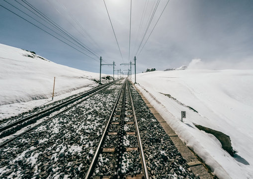 Driver view of train crossing snow mountain