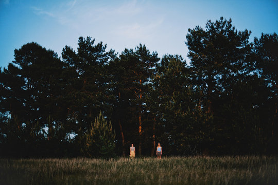 Two girl standing in the forest